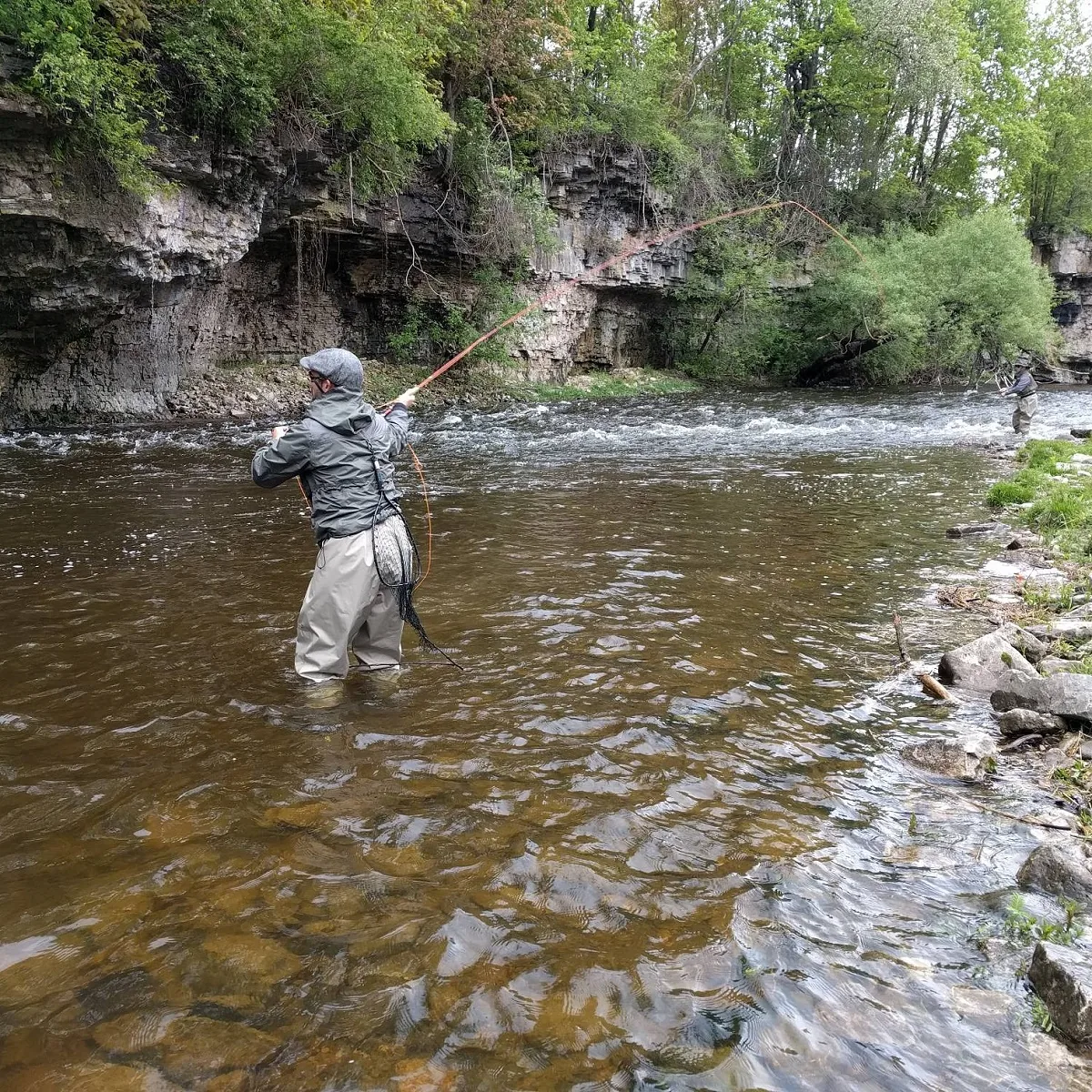 Anglers wading and fly fishing a broad run on the Grand River in Ontario.