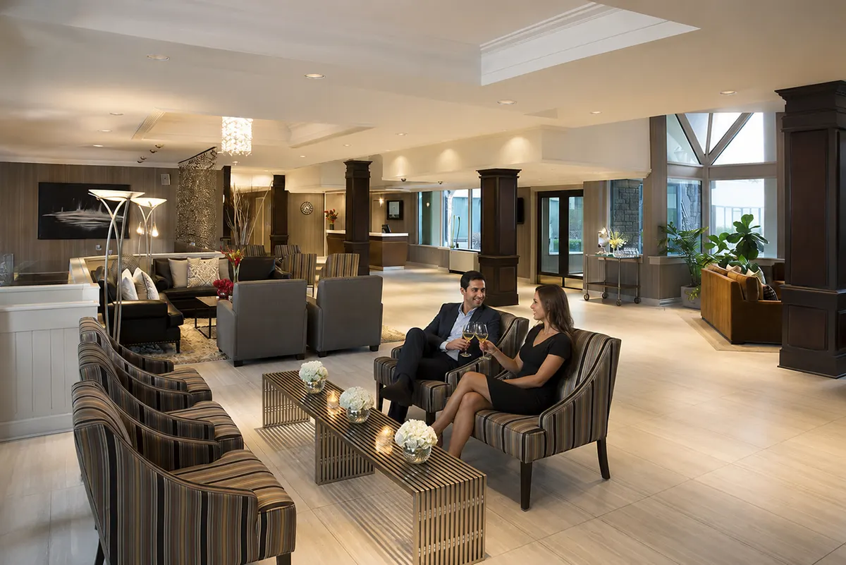 The lobby lounge at Hockley Valley Resort, with striped armchairs, low tables and guests sitting with glasses of wine.